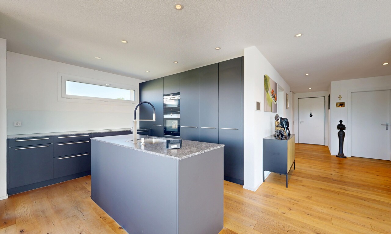 cuisine avec armoires à panneau plat, flat panel cabinets, light countertops, light floor, et sol en finition bois