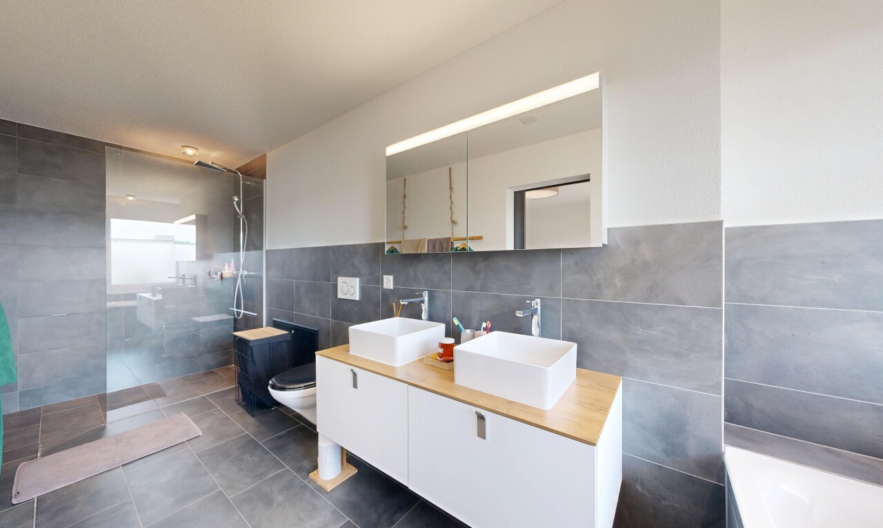 salle de bains avec mur en carrelage, tile wall, salle de bain complète, douche, et double vasque