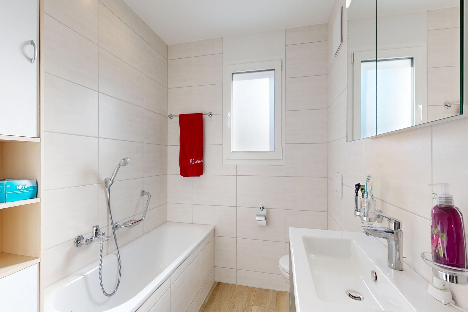 full bath with vanity, tile walls, a bath, and light wood finished floors