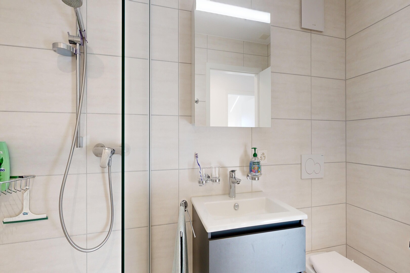 bathroom featuring vanity, tile walls, and a tile shower