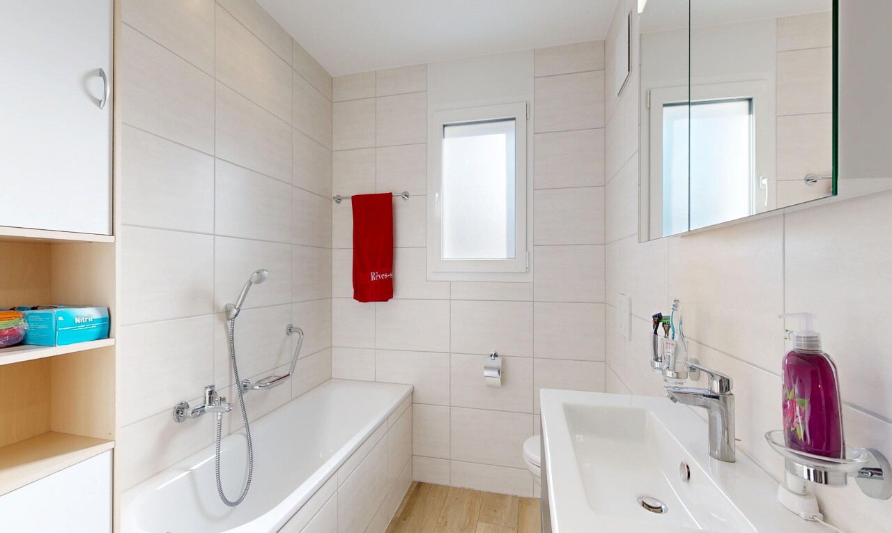 full bath with vanity, tile walls, a bath, and light wood finished floors