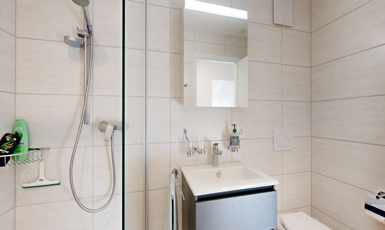 bathroom featuring vanity, tile walls, and a tile shower