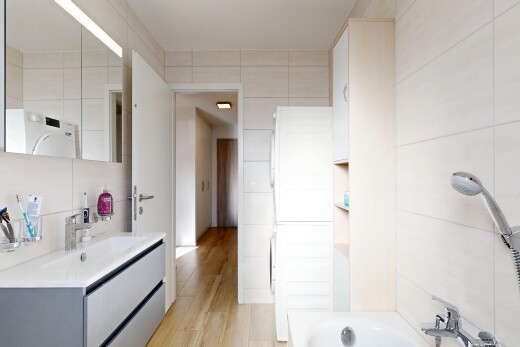 full bathroom with vanity, washer / clothes dryer, light wood-type flooring, shower / bathtub combination, and tile walls
