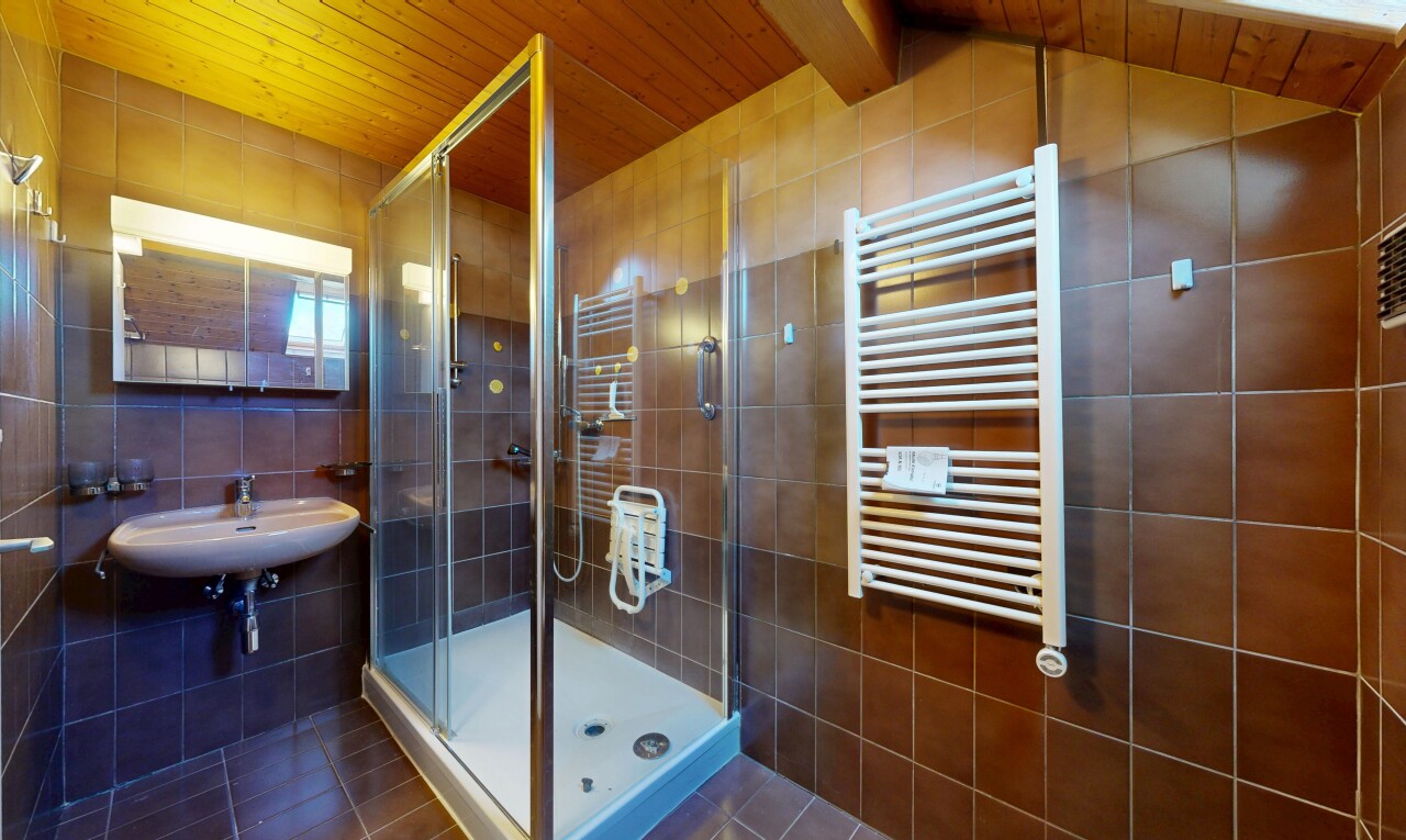 salle de bains avec chauffe-serviettes, douche, salle de bain complète, radiateur, et wood ceiling