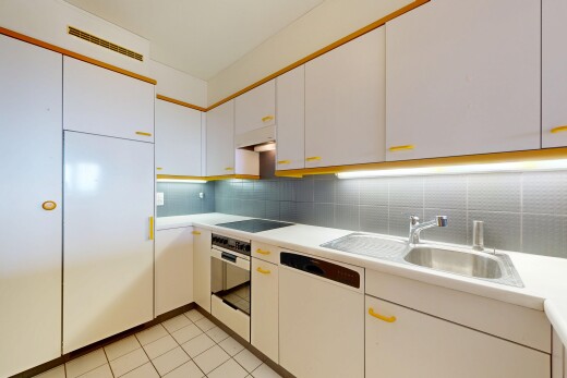 cuisine avec armoires blanches, white cabinets, plans de travail, light countertops, et light floor