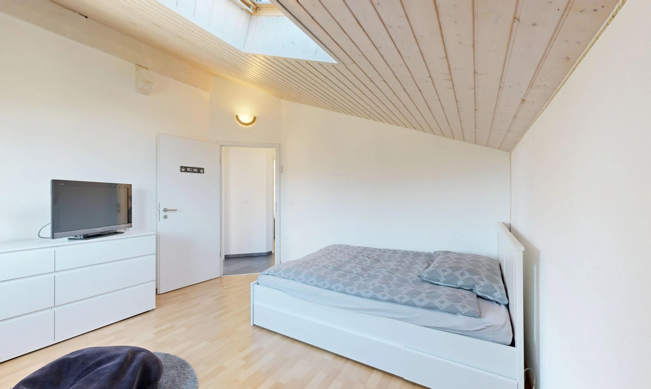 zimmer / schlafzimmer mit dachschräge, vaulted ceiling, gipskartonwand, drywall, und fernseher