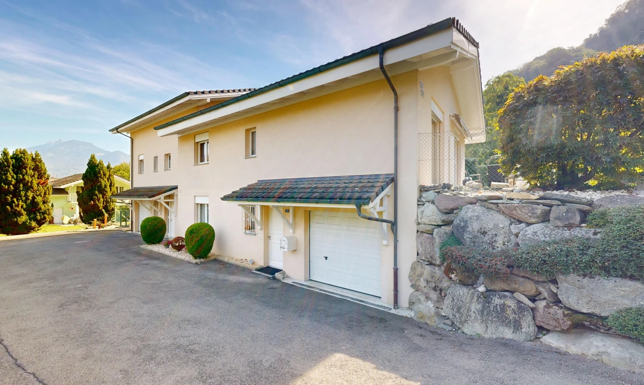außenansicht mit eingebaute garage, property visible, stuckverkleidung, und day time