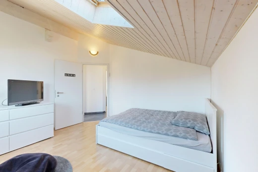 zimmer / schlafzimmer mit dachschräge, vaulted ceiling, gipskartonwand, drywall, und fernseher