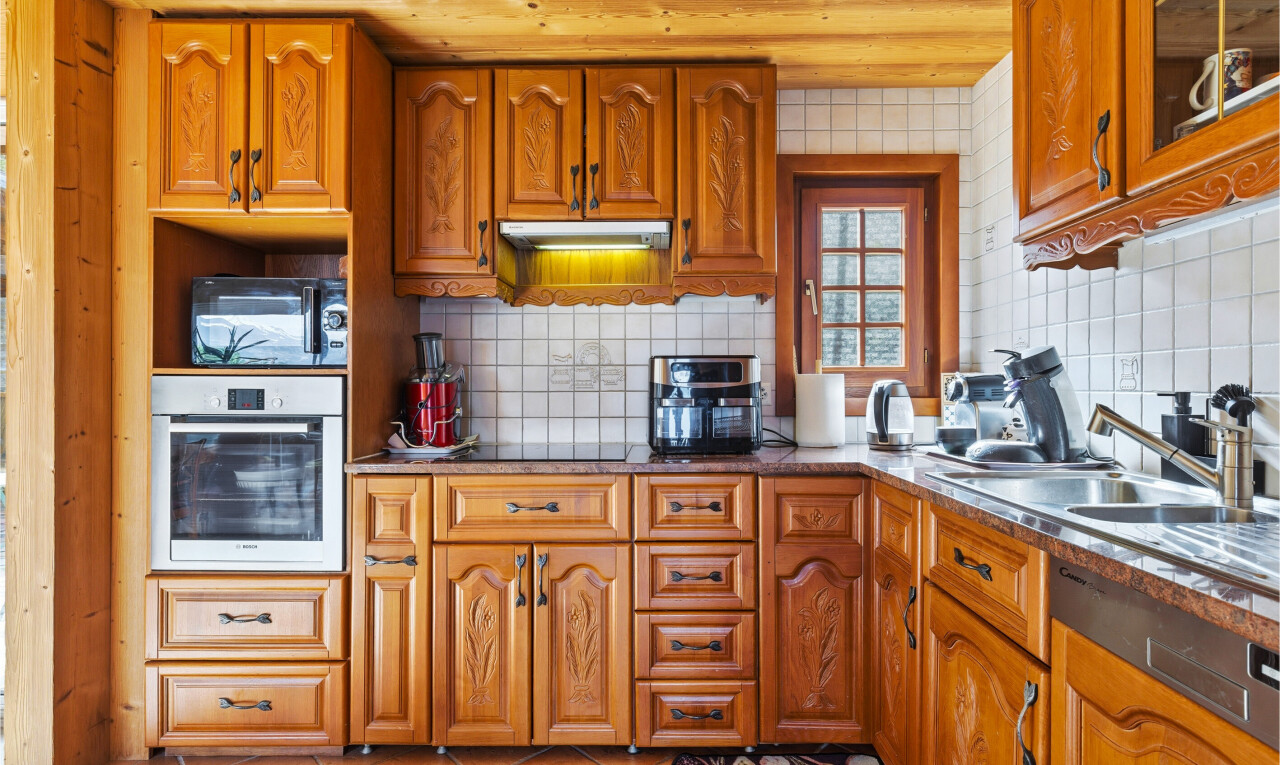 kitchen with black appliances, wood finish cabinetry, decorative backsplash, and light tile patterned flooring