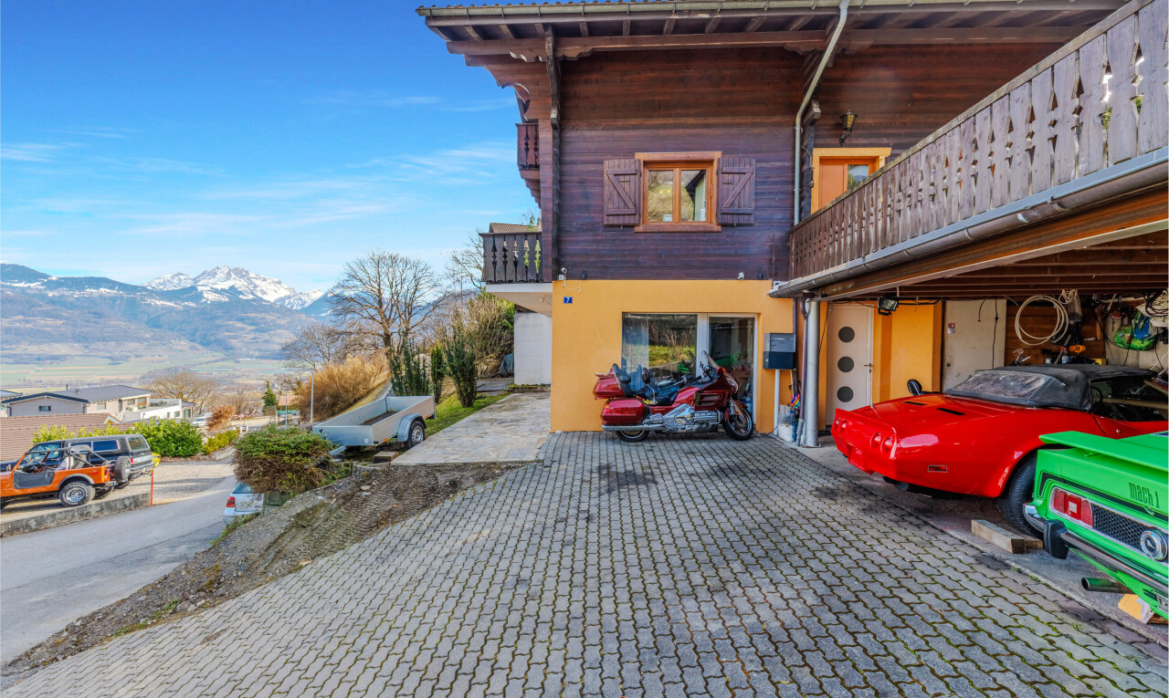 outdoor house featuring a balcony, a mountain view, and stucco siding