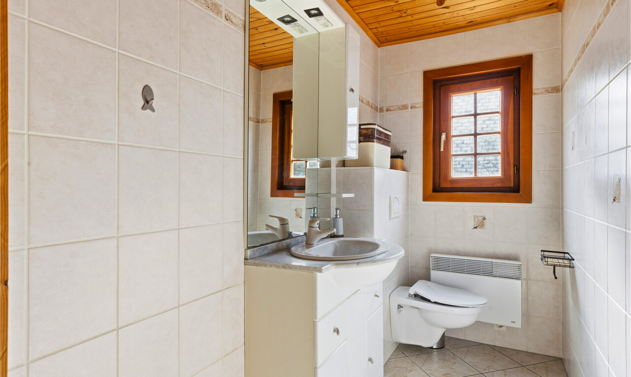 bathroom with tile walls, wooden ceiling, vanity, light tile patterned flooring, and heating unit