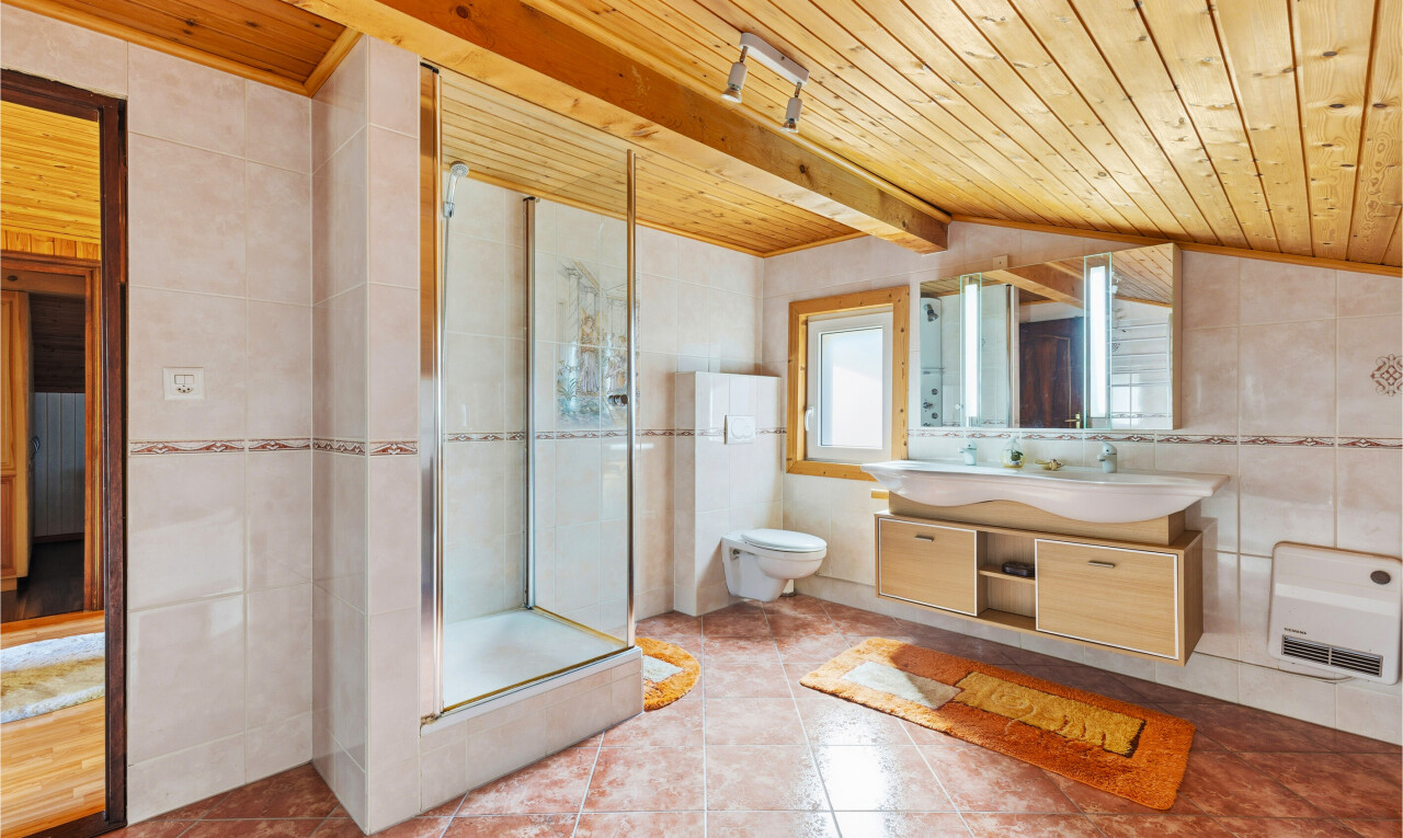 full bathroom with a stall shower, tile walls, wooden ceiling, vanity, and vaulted ceiling with beams