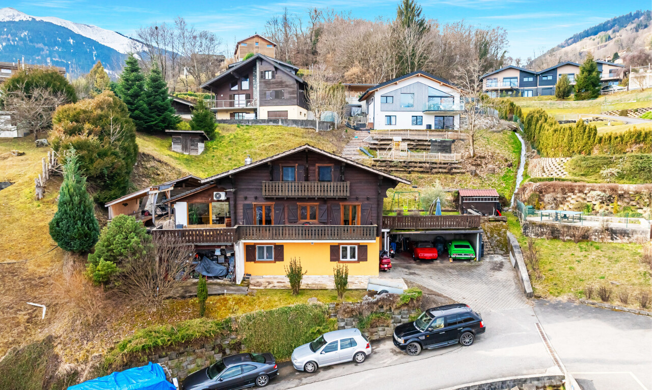 outdoor house featuring a mountain view, a balcony, and driveway