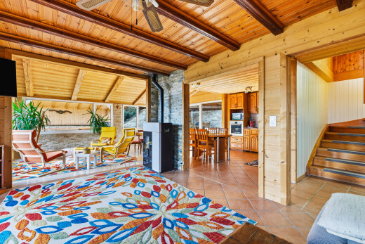 zimmer / schlafzimmer mit holzofen, balkendecke, beamed ceiling, natürliches licht, und natural light