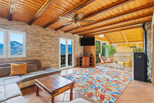 wohnzimmer mit fernseher, deckenventilator, beamed ceiling, balkendecke, und natural light