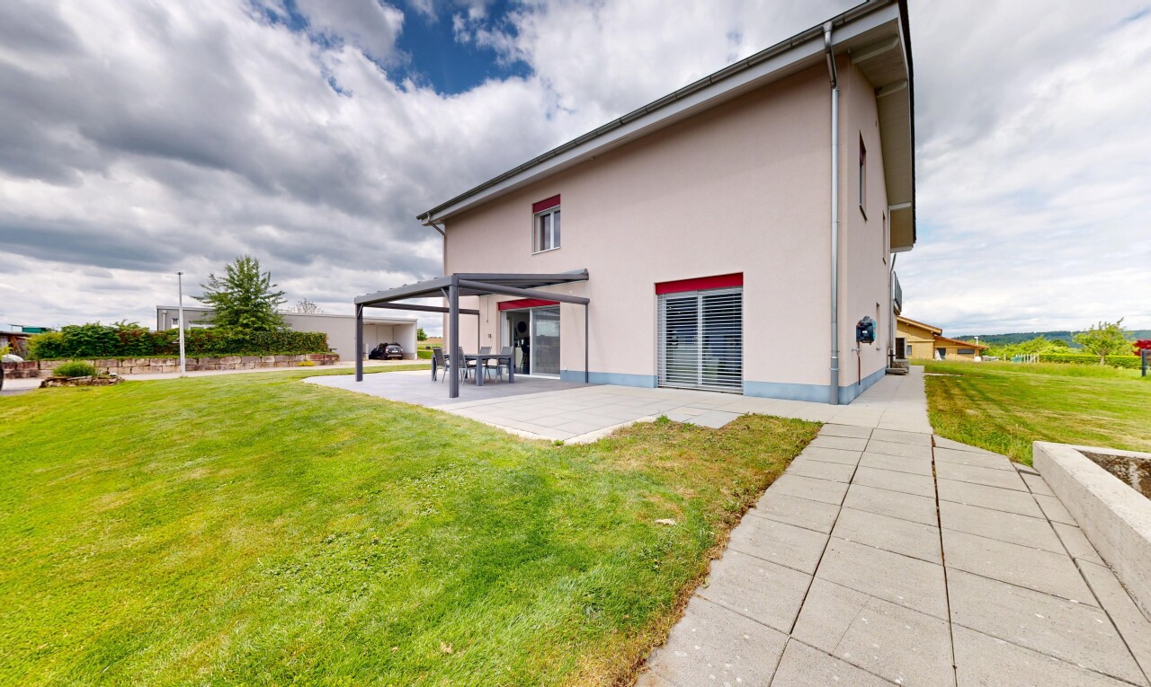 außenansicht mit rasen, property visible, stuckverkleidung, betonfundament, und terrasse