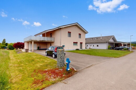 außenansicht mit auffahrt, rasen, day time, stuckverkleidung, und garage angeschlossen