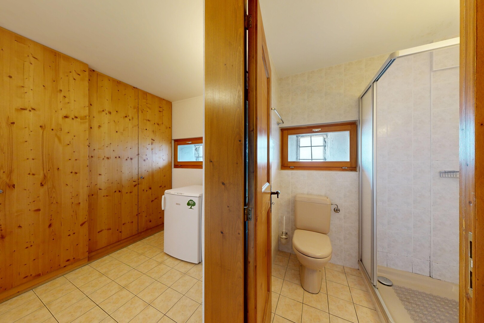 salle de bains avec toilette, douche, salle de bain complète, dated wood wall, et mur en bois