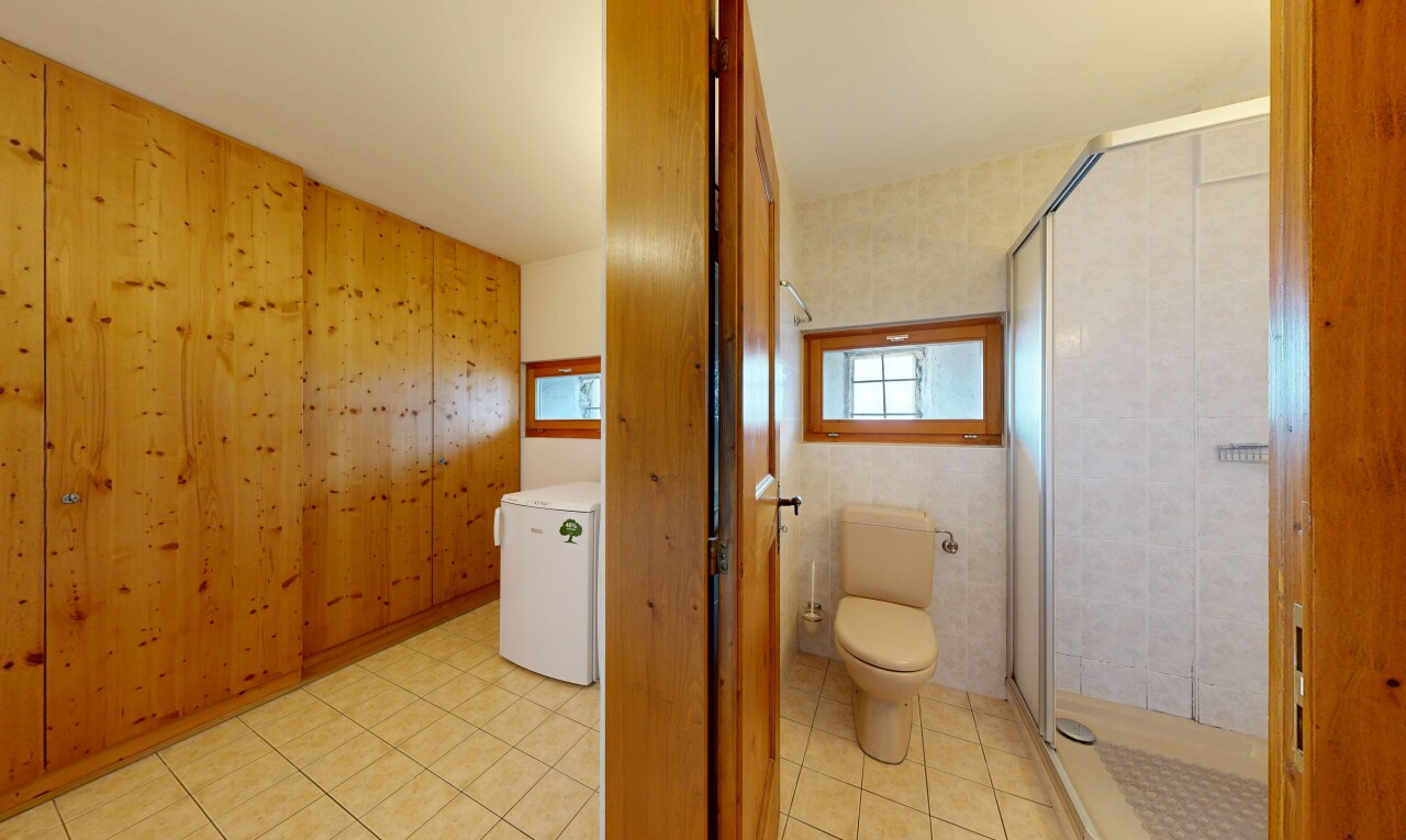 salle de bains avec toilette, douche, salle de bain complète, dated wood wall, et mur en bois