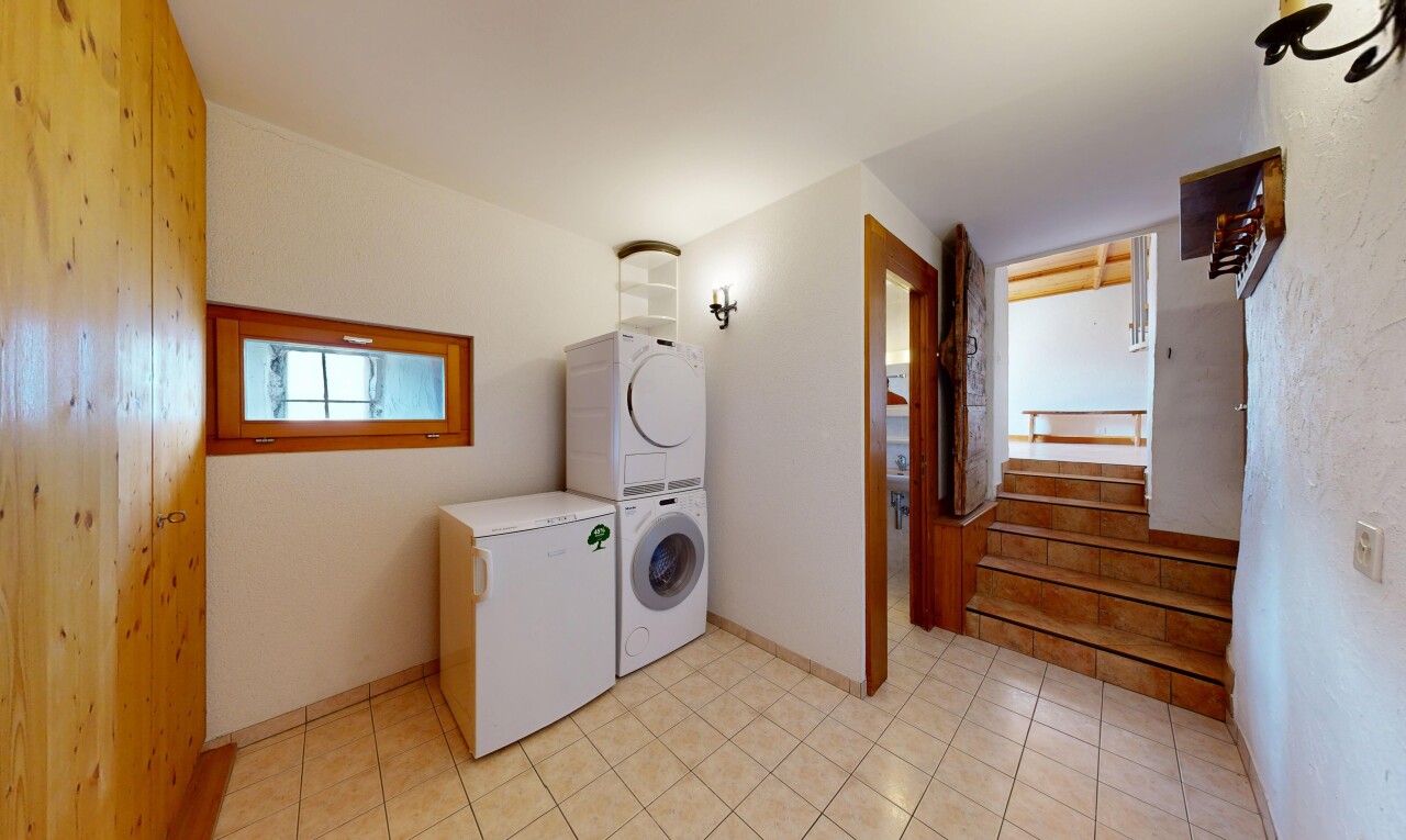buanderie avec lave-linge et sèche-linge superposés, escaliers, inside property, lumière naturelle, et light floor