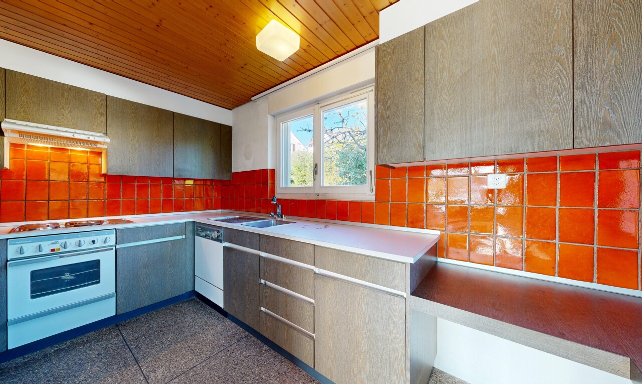 cuisine avec four, dark floor, natural light, lumière naturelle, et inside property