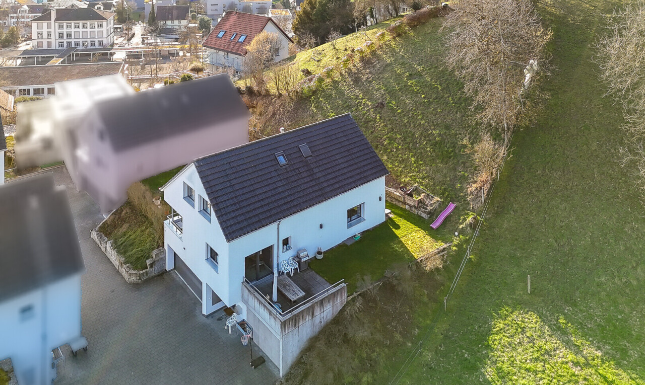 außenansicht mit eingebaute garage, deck, auffahrt, drone view, und stuckverkleidung