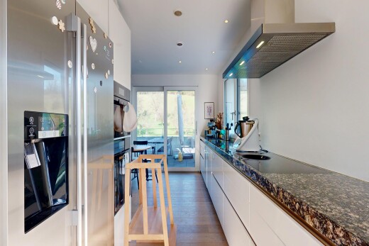 cuisine avec réfrigérateur, hotte, armoires blanches, white cabinets, et dark countertops