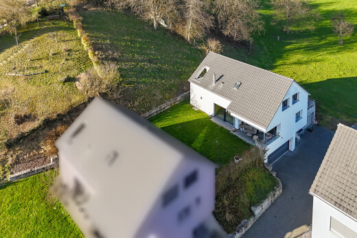 façade avec property visible, pelouse, bardage en stuc, terrasse, et garage intégré