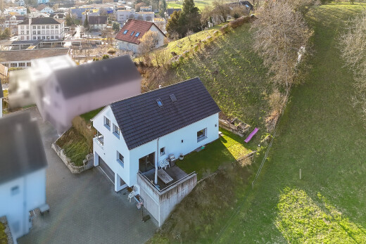 façade avec garage intégré, terrasse, allée, drone view, et bardage en stuc