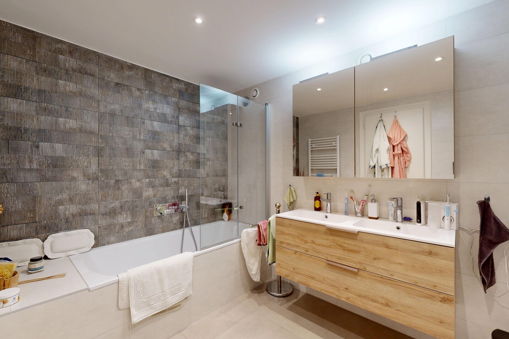 salle de bains avec salle de bain complète, double vasque, tile wall, mur en carrelage, et douche-bain combinés