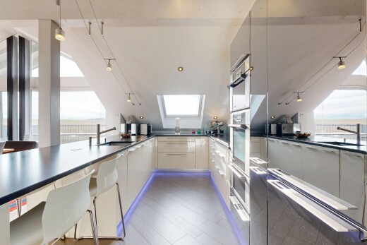 kitchen with plenty of natural light, dark countertops, a peninsula, and decorative light fixtures