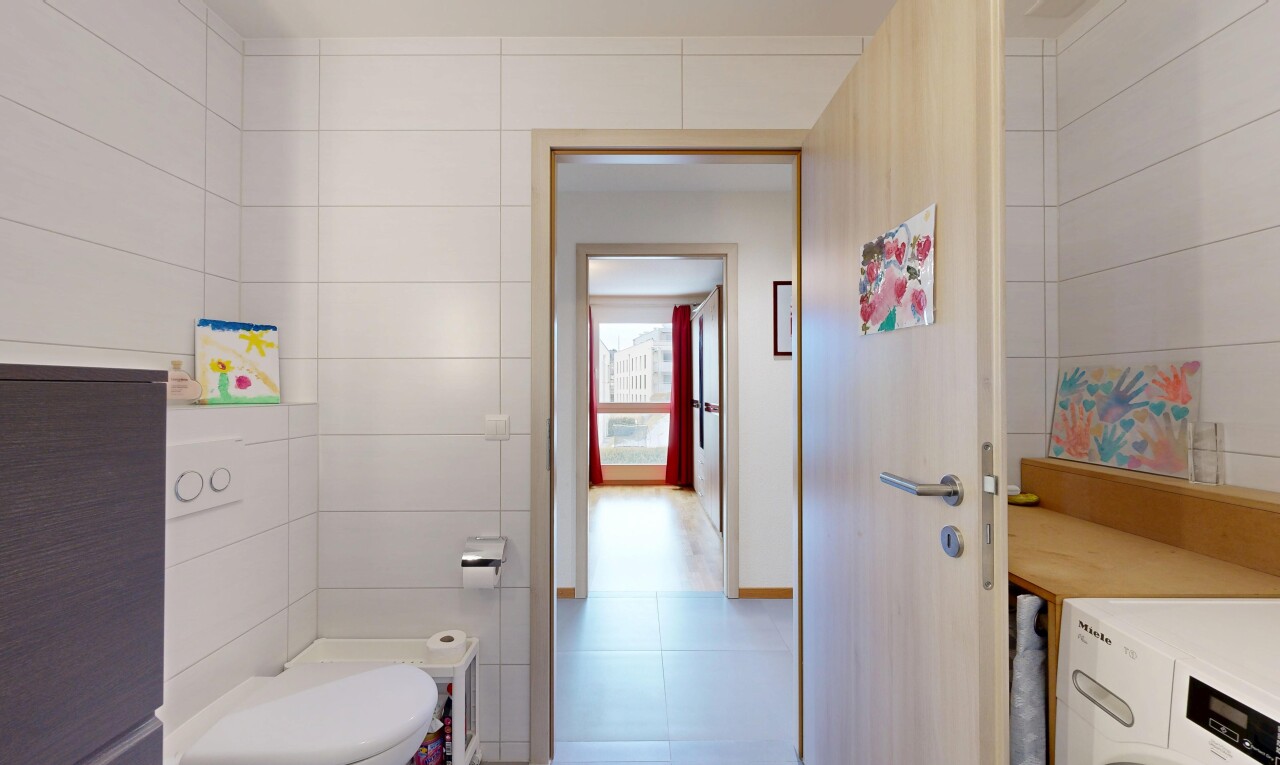 half bath with tile walls and washer / clothes dryer