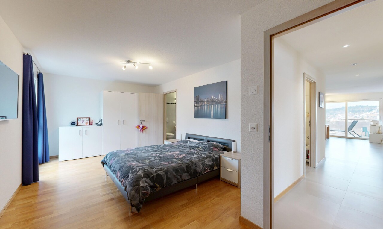 room with light wood finished floors, a closet, and ensuite bath