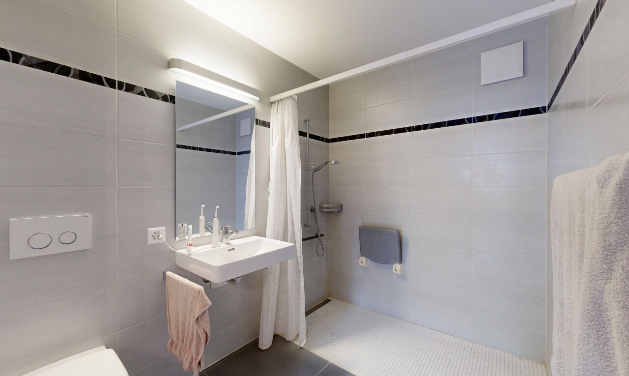 full bath featuring tile walls and a stall shower