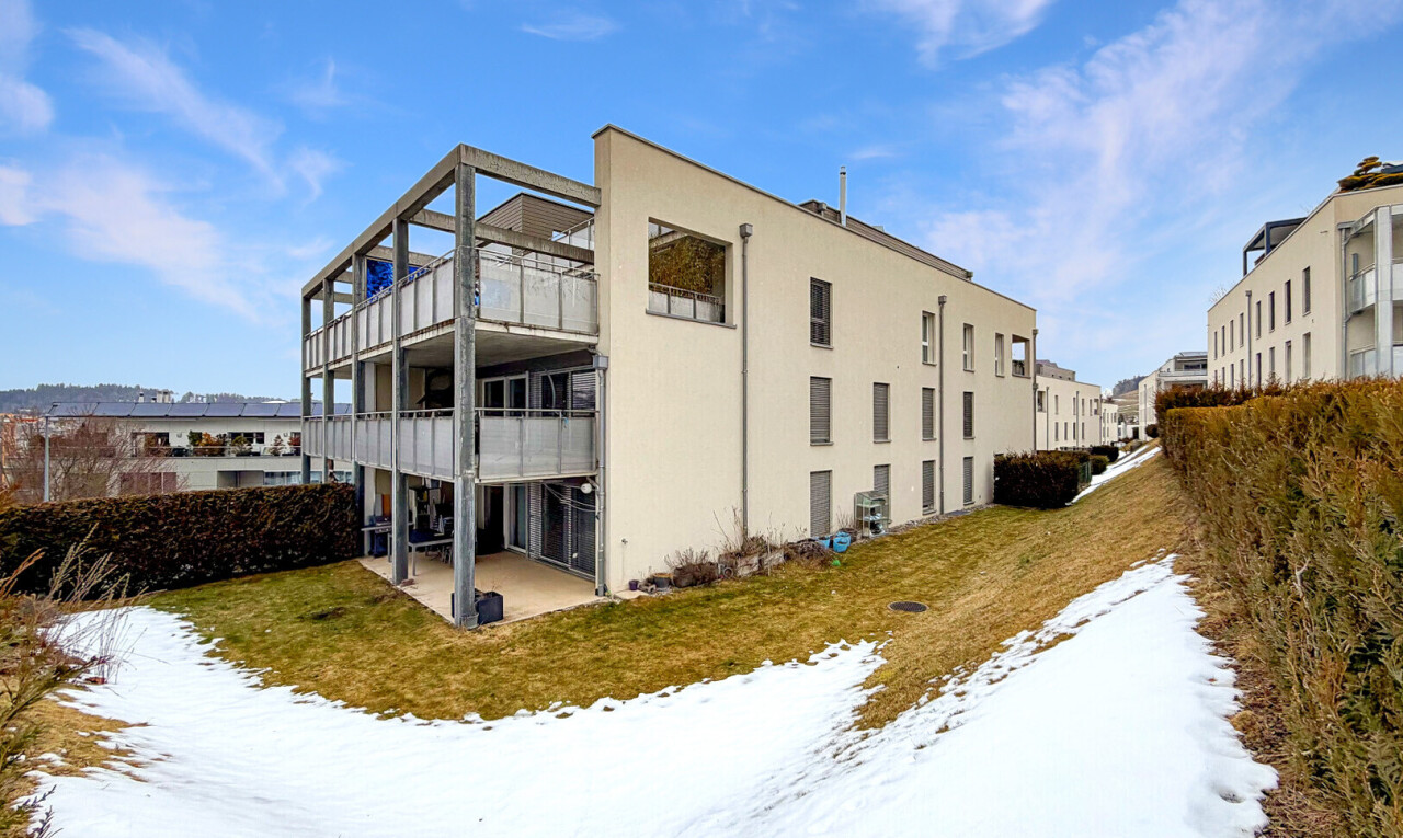 snow covered building with a view of apartment building / complex