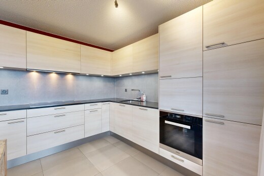 cuisine avec four, dark countertops, plans de travail, inside property, et light floor
