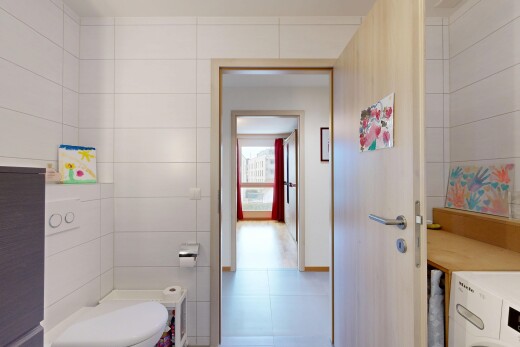 salle de bains avec tile wall, mur en carrelage, toilette, inside property, et lave-linge et sèche-linge