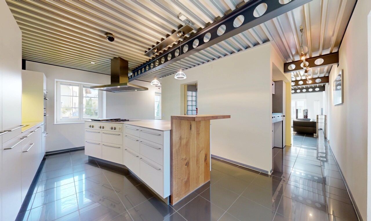 cuisine avec hotte, light countertops, plans de travail, dark floor, et white cabinets