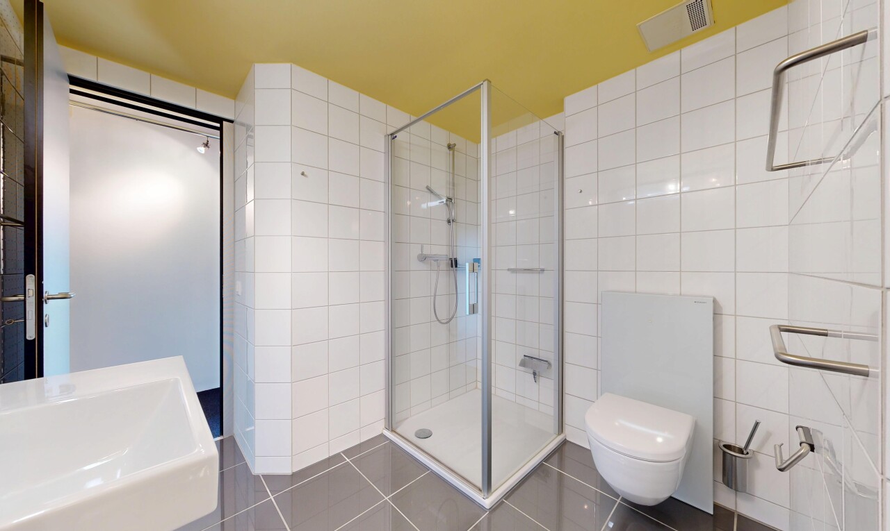 salle de bains avec toilette, mur en carrelage, tile wall, inside property, et douche
