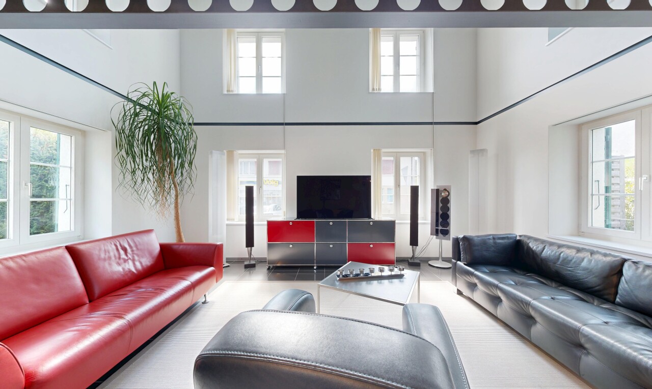 salon avec inside property, télévision, high ceiling, plafond haut, et drywall