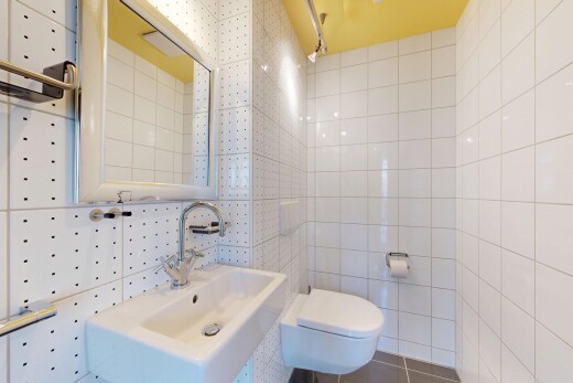 salle de bains avec toilette, tile wall, mur en carrelage, inside property, et miroir