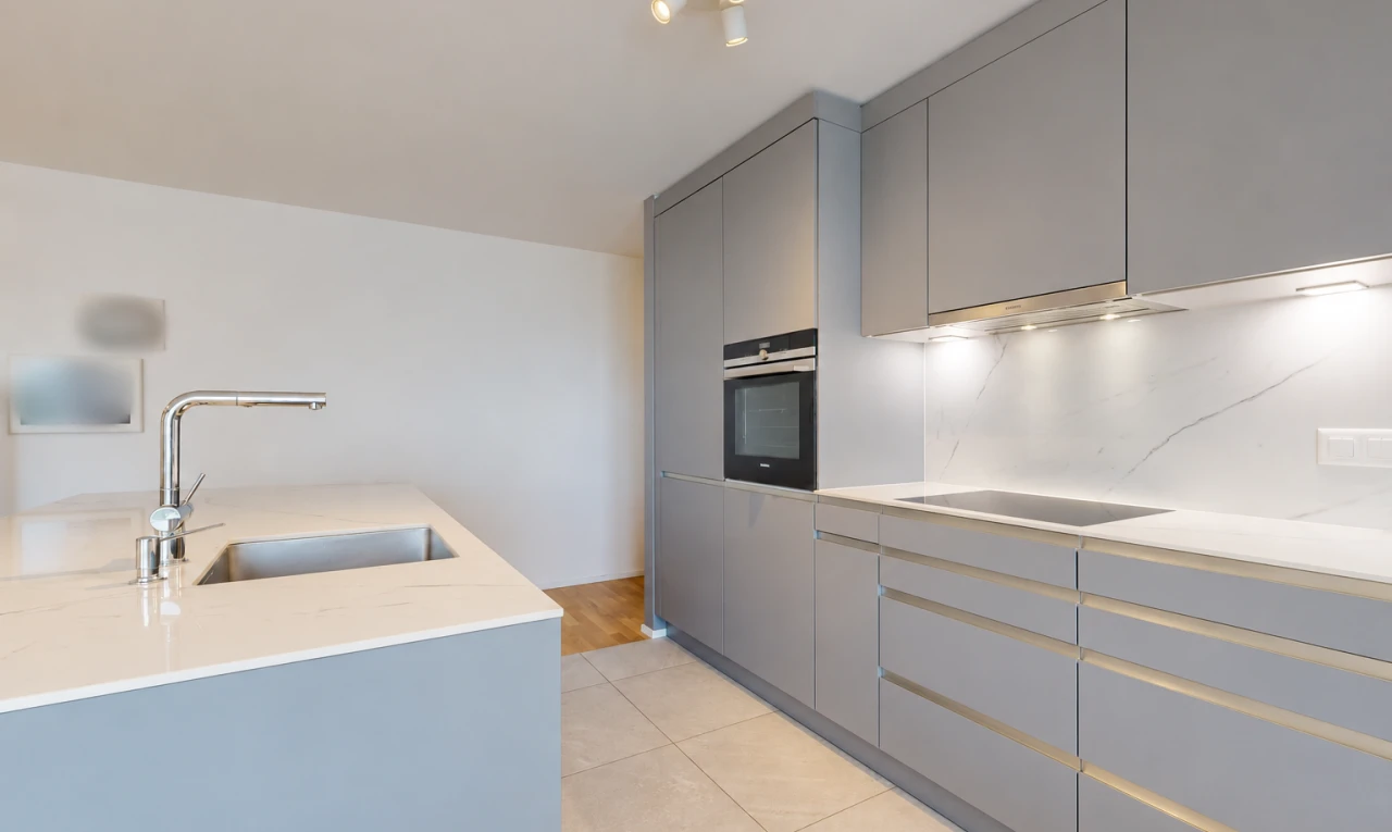 cuisine avec light countertops, light floor, four, évier, et armoires grises