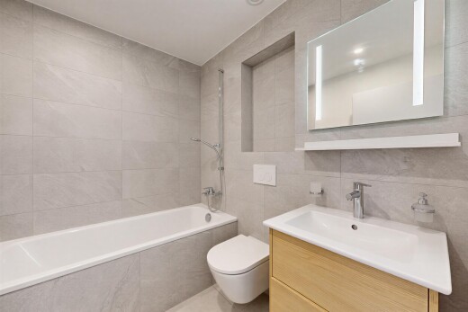 bathroom featuring tile walls, vanity, and tiled shower / bath combo