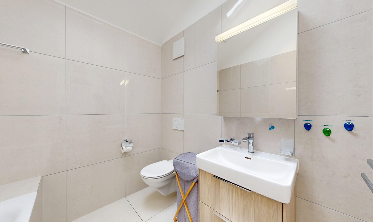 salle de bains avec tile wall, mur en carrelage, lavabo (ou coiffeuse selon le contexte), inside property, et light floor