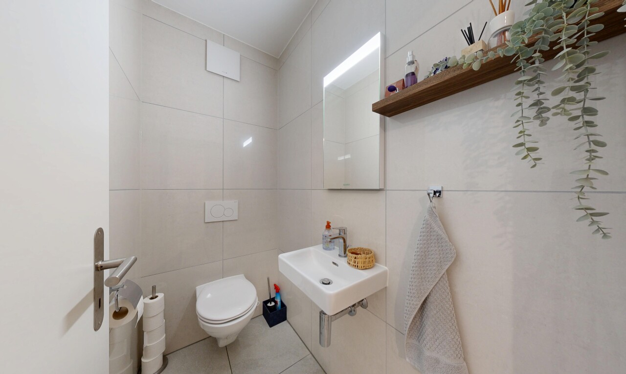 salle de bains avec miroir, tile wall, mur en carrelage, toilette, et inside property