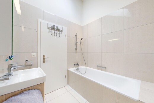 salle de bains avec mur en carrelage, tile wall, light floor, salle de bain complète, et lavabo (ou coiffeuse selon le contexte)