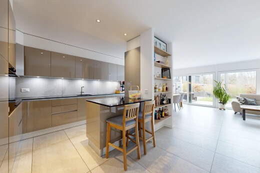 cuisine avec armoires à panneau plat, flat panel cabinets, dark countertops, bar de cuisine, et kitchen bar