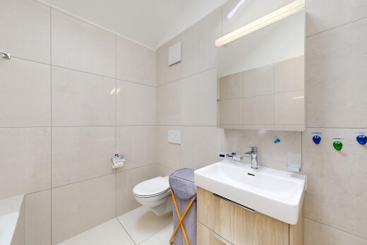 salle de bains avec tile wall, mur en carrelage, lavabo (ou coiffeuse selon le contexte), inside property, et light floor