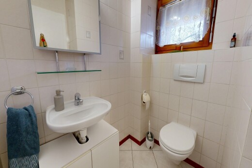 salle de bains avec toilette, miroir, mur en carrelage, tile wall, et sol en carrelage