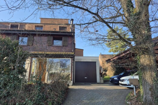 façade avec allée, day time, garage attaché, property visible, et bardage en bois